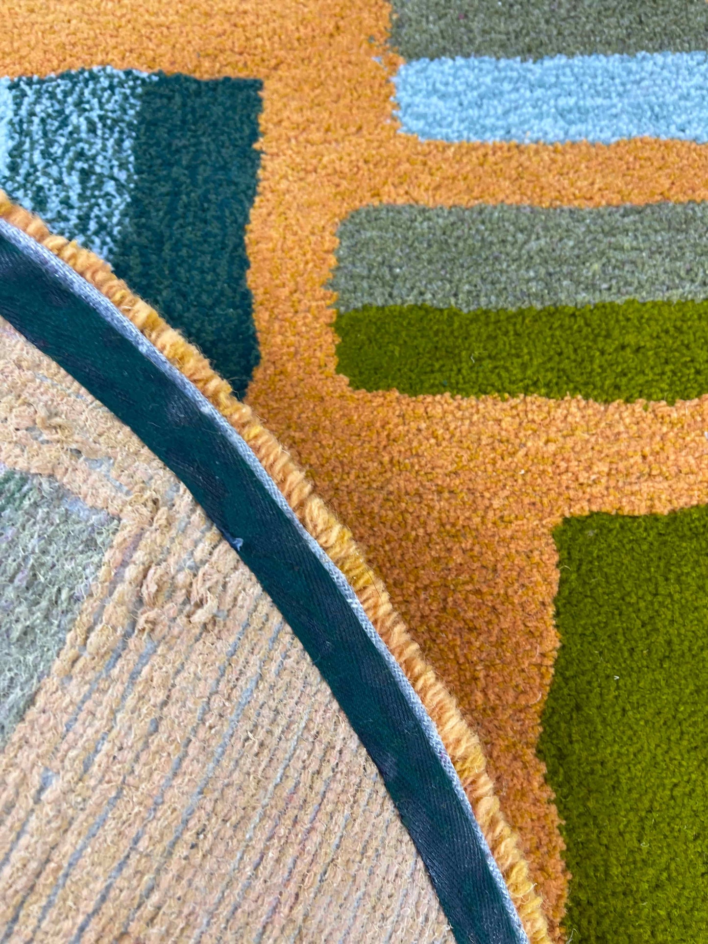 'Hitomi' Hand tufted ochre mustard, dark green and teal circular small tufted rug